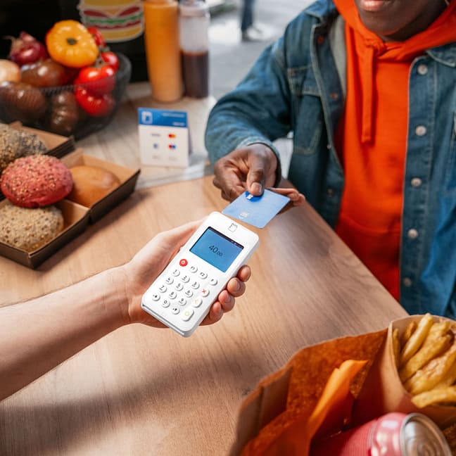 Customer paying with a card on a myPOS terminal at a bakery counter